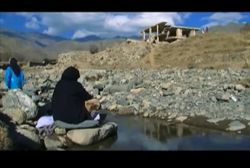 アフガニスタンの川辺で洗濯をする母娘