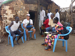 日々の会話の中からネタを探します 現地の人々と話す角谷亮(左から二人目)