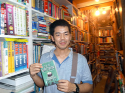 手には流行のダン・ブラウンの小説を イスラマバードの古本屋にて。山浦遼