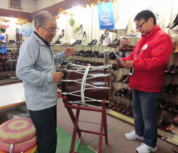 新川太鼓店で太鼓を前に、新川さんと及川
