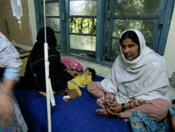 点滴を受けながら1歳の孫を世話するハミールさん 点滴を受けながら1歳の孫を世話するハミールさん