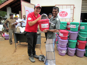 五十嵐豪（左）が被災者に支援物資を配付します