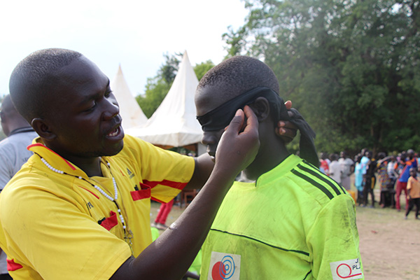 審判が選手の顔に黒い布の目隠しをつけている