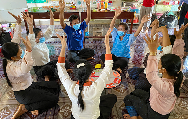 7名の男女があぐらをかきながら円座になって取り組んでいます