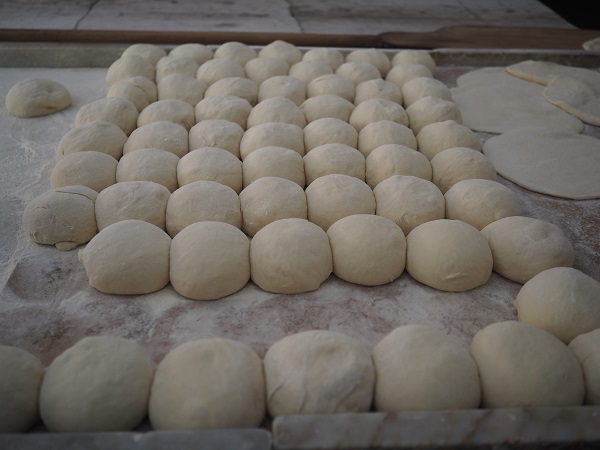 "30個ほどきれいに並べられた丸いパン生地