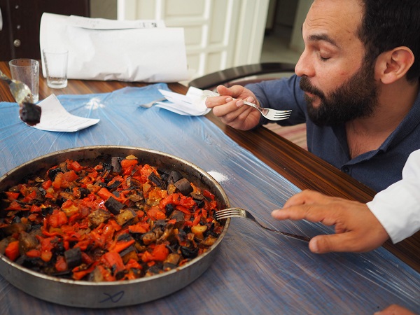 一口食べて目をつむって味わう事務所長の男性。