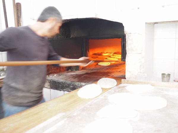 焼き担当の男性が素早くオーブンにパンを入れていく。早くて手元がブレている。