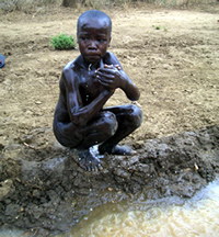 泥水で体を洗う子ども
