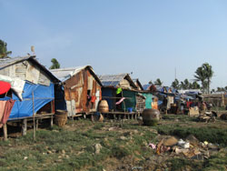廃材を利用した掘っ立て小屋で雨露をしのぐ村人たち