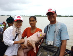 子豚を配布する久保田駐在員(左) 子豚を配布する久保田駐在員(左)