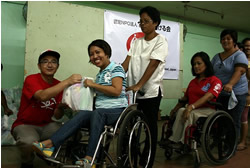 写真左は東京事務局の大西 生活物資を手渡す東京事務局の大西