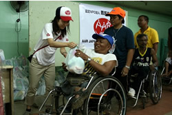 生活物資を手渡す東京事務局の広谷 生活物資を手渡す東京事務局の広谷