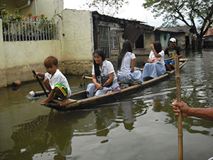 水が引くのはいつのことか 冠水した道路を進むカヌー