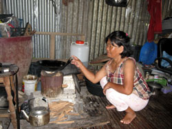 台風で家が吹き飛ばされそうに。今も半壊ながら生活を続けています 食事の準備をするバシータさん