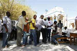 人々は事前に配布したクーポンと引き換えに、順番に支援物資を受け取る 人々は事前に配布したクーポンと引き換えに、順番に支援物資を受け取る