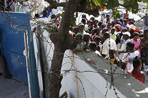 配布の順番を校庭の外で待つ人々 配布の順番を校庭の外で待つ人々