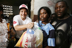 女性に食料を手渡すスタッフ 女性に食料を手渡すスタッフ