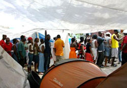 クーポンを手に、物資配布の列に並ぶ人々 act1004-4-2coupon-s.jpg