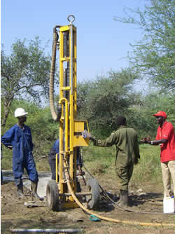 機械はケニアから運んできます 掘削機を使って井戸を掘っている