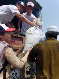 物資1袋は約20キロの重さ 支援物資をトラックから運び出す川邉(右)と大西