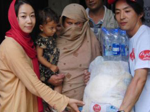 親子で配付を待つ姿も見られました 支援物資を被災者に手渡す青木(左)と杉澤(右)