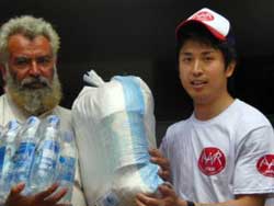 被災者は笑顔で受け取ってくれました 被災者に支援物資を渡す川邉(右)