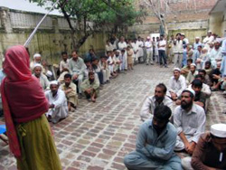 左は挨拶する協力団体GPPの代表 支援物資を待つノシェラ・カランの人々