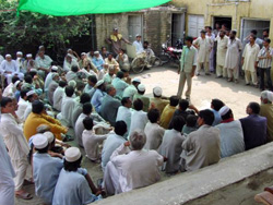 支援物資受け取りの前に説明を受けます 物資を受け取りに集まった人々