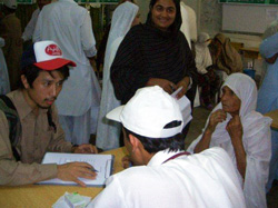 一人ひとりから話を伺います 被災者をインタビューする川邉(左)