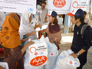 ジャンさん(左から2人目)の話を聞く野際紗綾子(右から2人目)と川邉安行(右端) 支援物資を受け取るジャンさん(左から2人目)