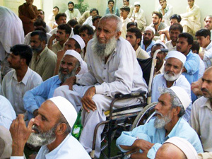 高齢者、障害者、未亡人などに優先的に物資配付を行っています 物資配付の会場に集まった人々