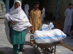 支援パッケージは重たくて一人で運ぶのは大変 受け取った支援物資を一輪車で運ぶ