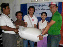 支援物資のお米を手にして喜ぶ被災者と難民を助ける会職員