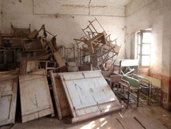 小学校の校舎内に積み上げられた机や椅子