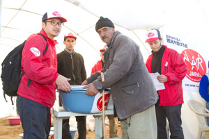 支援物資を受け取りに来た村人と大西清人