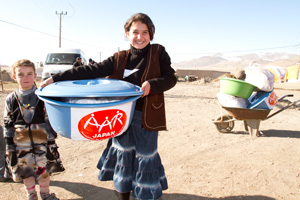 大きなたらいを抱えて笑顔を見せる少女