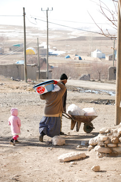 一輪車に支援物資を載せて帰る家族