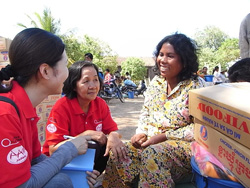 受け取った支援物資を前に笑顔を見せるティーさん