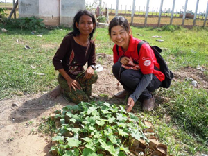 手作りの育苗ポットで育った苗を前に、受益者と園田知子