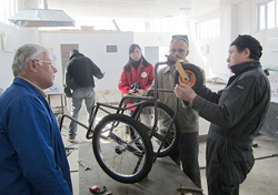 車いすを組み立てる南専門家と工房職員