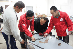 パイプを曲げる作業をする南専門家と工房職員