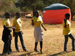 検査が受けられるテントの前で詩の朗読をするクラブのメンバー