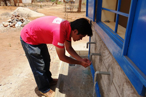 水給水所にて水の流れを確認する駐在員の高城大吾