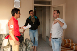 室内で男性二人に話を聞く大西