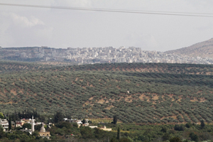 丘の向こうにぼんやりと建物群が見える