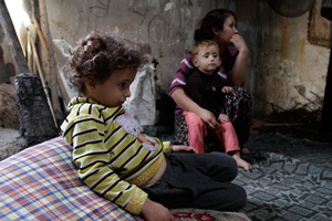 部屋の中で二人の子どもと女性