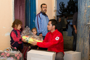 東京事務局の景平義文から支援物資を受け取る子どもたち