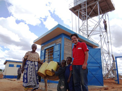 水販売所と給水塔の前で