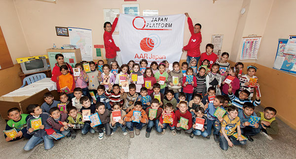 自分たちの教材を持って子どもたちは大喜びです シリア人の小学校に教材を配付した雨宮知子と景平義文