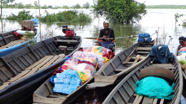 川の上で、小舟に積まれた支援物資